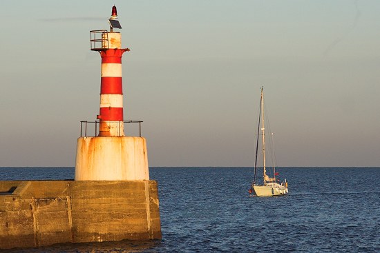 Yacht approaching Amble Lighthouse.