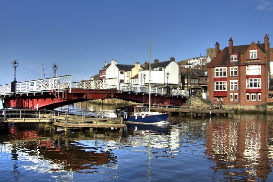 Yacht passing through open swing bridge at Whitby Harbour.