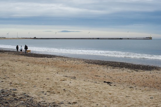 Dog walkers at Blyth South Beach, Northumberland Coast.