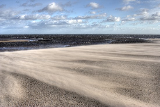 Sand blasting across the beach at the mouth of the River Aln at Alnmouth, Northumberland Coast.