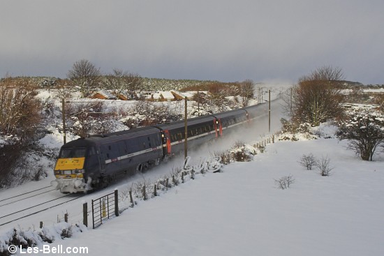 High speed passenger train in the snow at Pegswood Station, Northumberland.