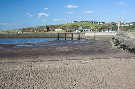 View along the Old Quay to the watchtower and inner harbour entrance .